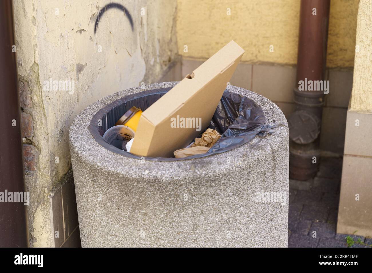 Full trash can on a city street. City street cleaning. Stock Photo