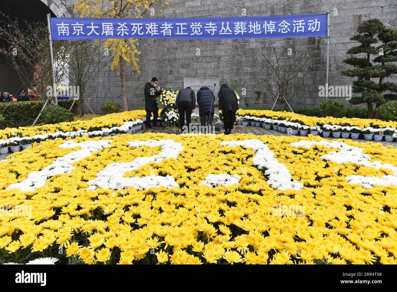 201213 -- NANJING, Dec. 13, 2020 -- People bow in front of a monument during an activity in commemoration of victims of the Nanjing Massacre at a mass burial place on the occasion of the seventh national memorial day in Nanjing, capital of east China s Jiangsu Province, Dec. 13, 2020. Photo by /Xinhua CHINA-NANJING MASSACRE-COMMEMORATION CN FangxDongxu PUBLICATIONxNOTxINxCHN Stock Photo