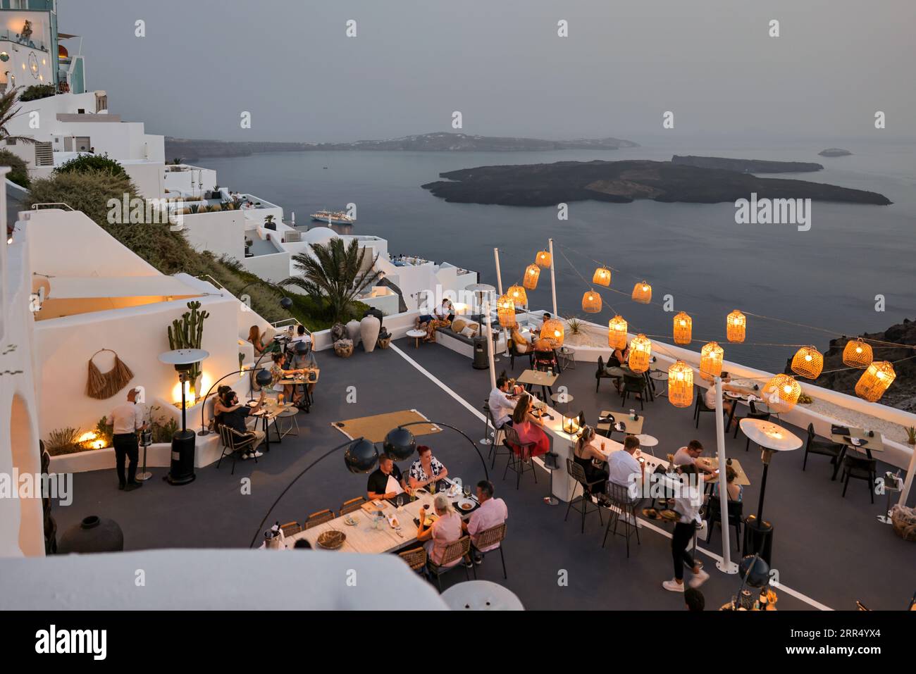 Imerovigli, Santorini, Greece - July 1, 2021: People having a romantic dinner on the panoramic terrace of a restaurant in Imerovigli, Santorini. Greec Stock Photo