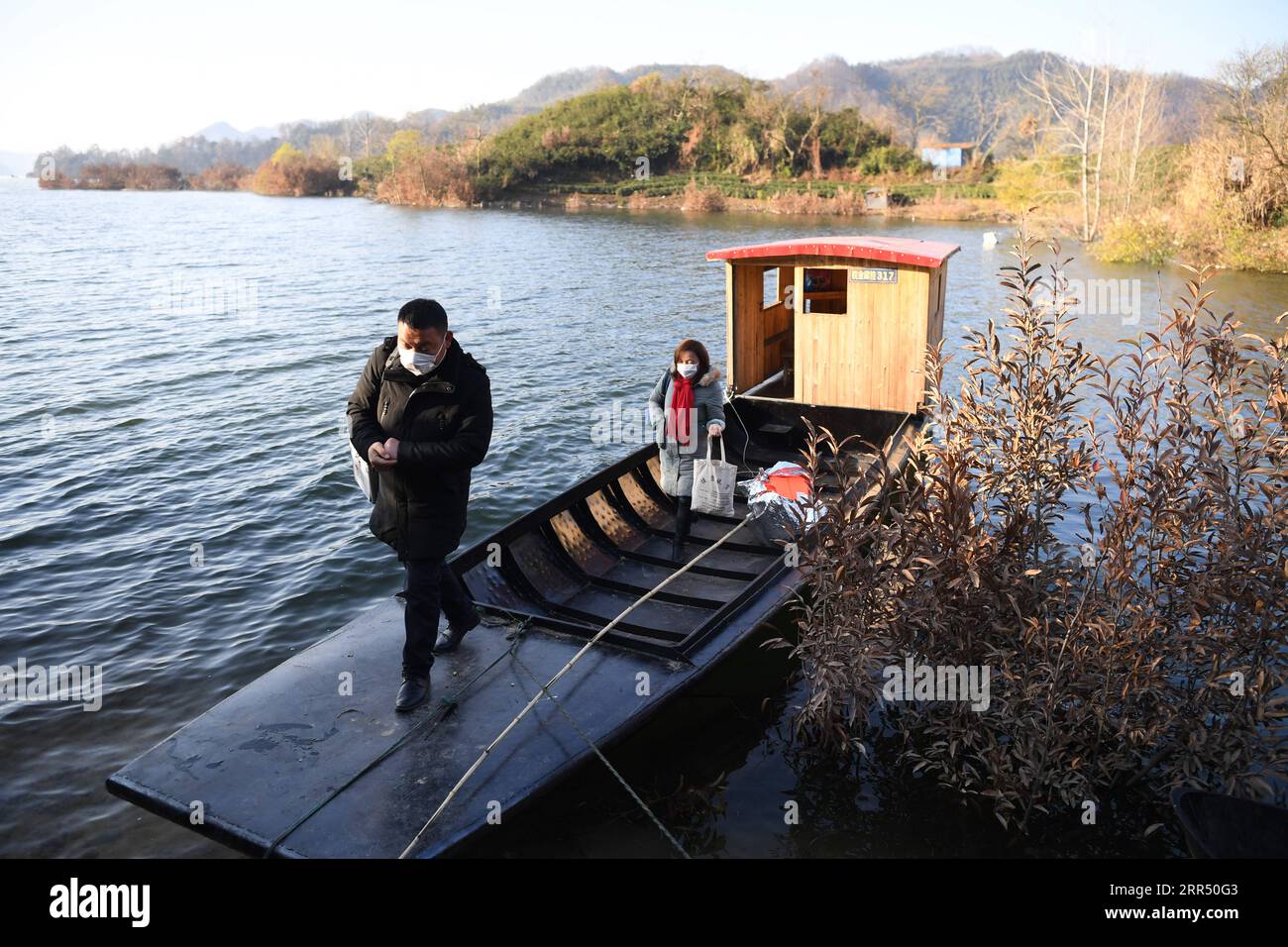 201218 -- JINZHAI, Dec. 18, 2020 -- Photo taken on Dec. 16, 2020 shows Yu Jiajun making a visit by his boat in Jinzhai County of Luan City, east China s Anhui Province. Deep in the Xianghongdian Reservoir area in Jinzhai County of Luan City, east China s Anhui Province, there is an isolated island, which used to be home to over 40 poor families. Yu Jiajun, 42, is the only doctor in the village. In the past, there was no health station on the island. Villagers had to row a boat for two or three hours to go to the health center in Mabu Township to see the doctor. Yu said. When Yu Jiajun returned Stock Photo
