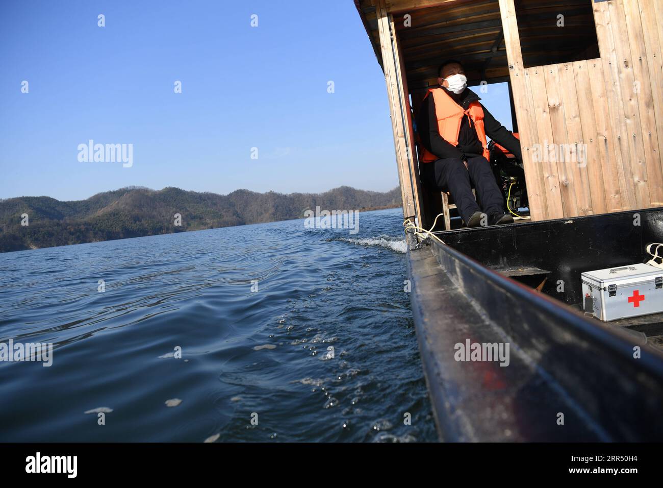 201218 -- JINZHAI, Dec. 18, 2020 -- Yu Jiajun drives his boat to make a visit in Jinzhai County of Luan City, east China s Anhui Province, Dec. 16, 2020. Deep in the Xianghongdian Reservoir area in Jinzhai County of Luan City, east China s Anhui Province, there is an isolated island, which used to be home to over 40 poor families. Yu Jiajun, 42, is the only doctor in the village. In the past, there was no health station on the island. Villagers had to row a boat for two or three hours to go to the health center in Mabu Township to see the doctor. Yu said. When Yu Jiajun returned to the village Stock Photo