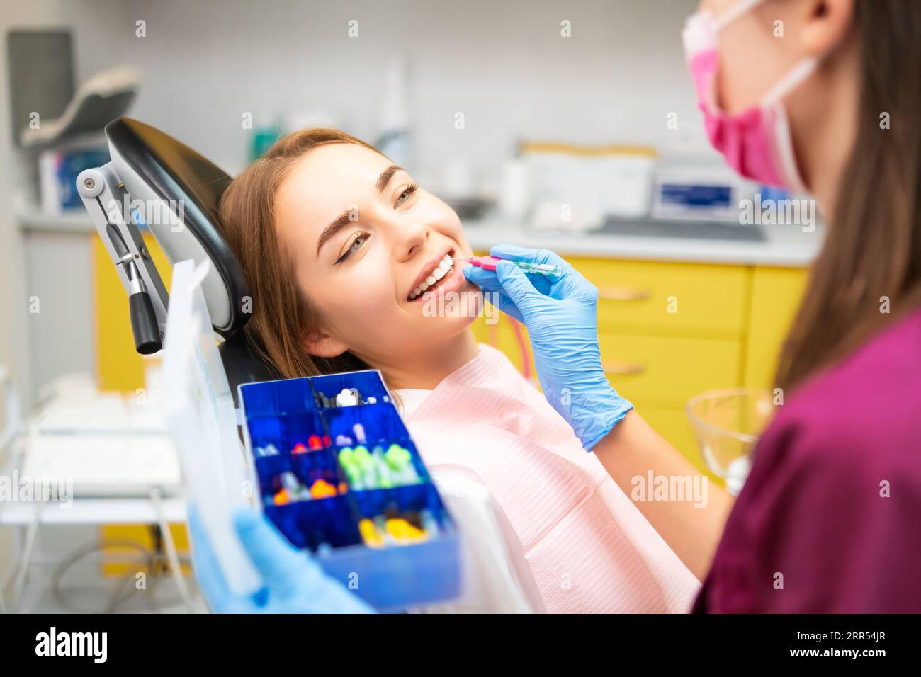 Dentist cleans teeth with interdental brush to young patient at the