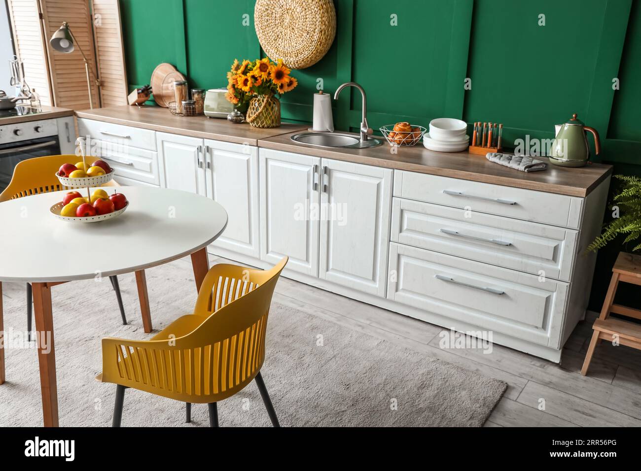 Interior of modern kitchen with white counters and dining table Stock ...