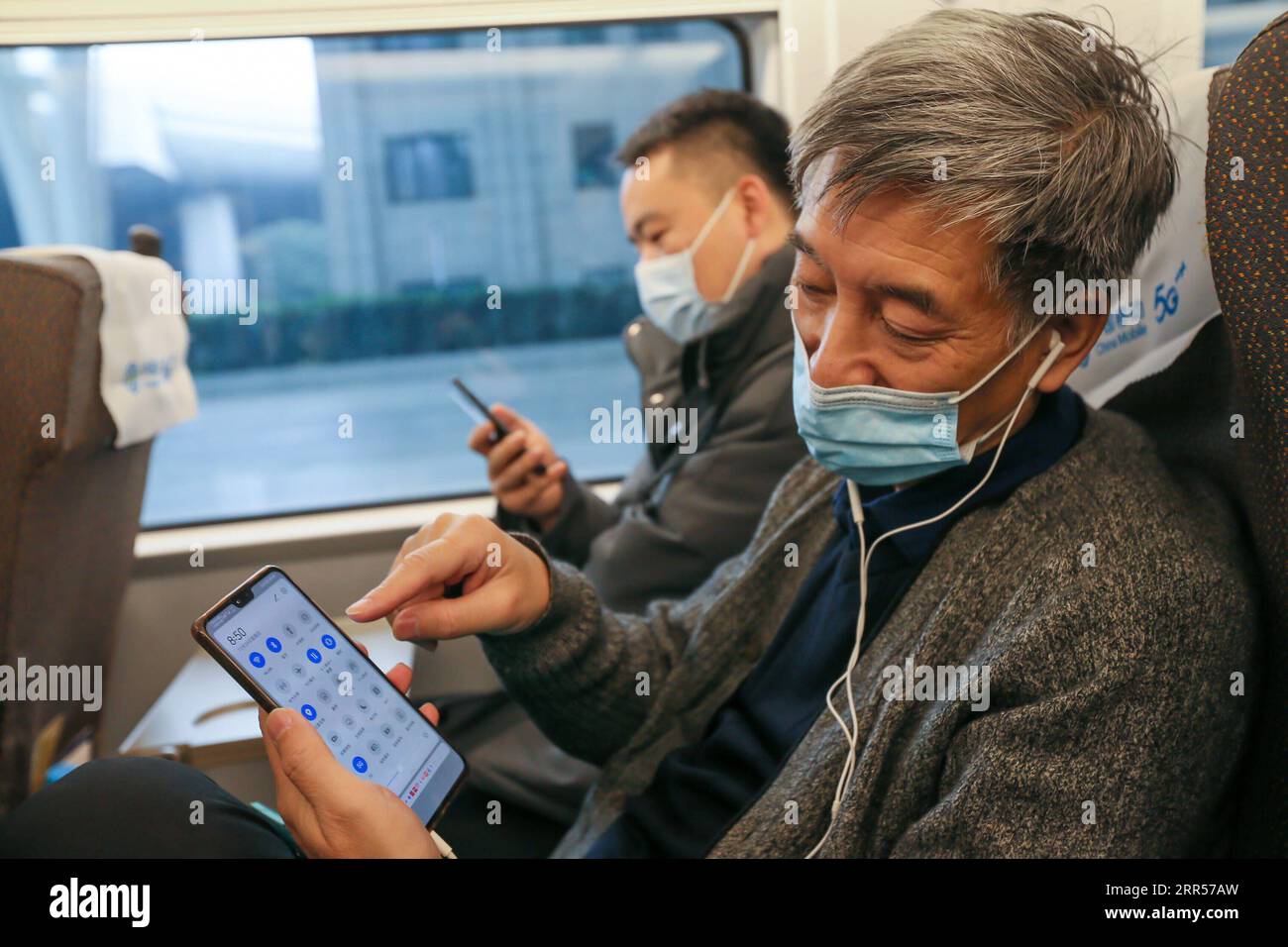 201224 SHANGHAI, Dec. 24, 2020 A passenger mutes his cellphone on