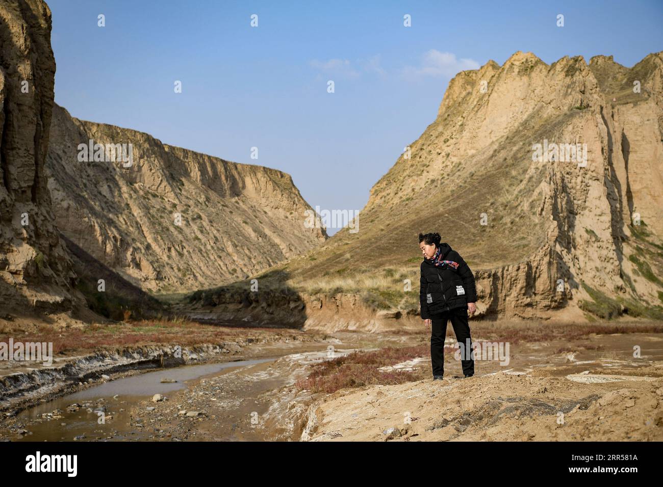 201225 -- YINCHUAN, Dec. 25, 2020 -- Ding Haiyan walks on the now obsolete trail leading to Hejiayuna Village of Xihaigu in northwest China s Ningxia Hui Autonomous Region, Oct. 28, 2020. Xihaigu, a largely mountainous region in northwest Ningxia, was once inflicted by deep poverty and labeled the most unfit place for human settlement by the United Nations in the 1970s due to land reclamation, drought, and a fragile ecological environment. On Nov. 16, 2020, Xihaigu historically bid farewell to absolute poverty, during which she power played an indispensable role. Ding Haiyan, 55, is chairwoman Stock Photo