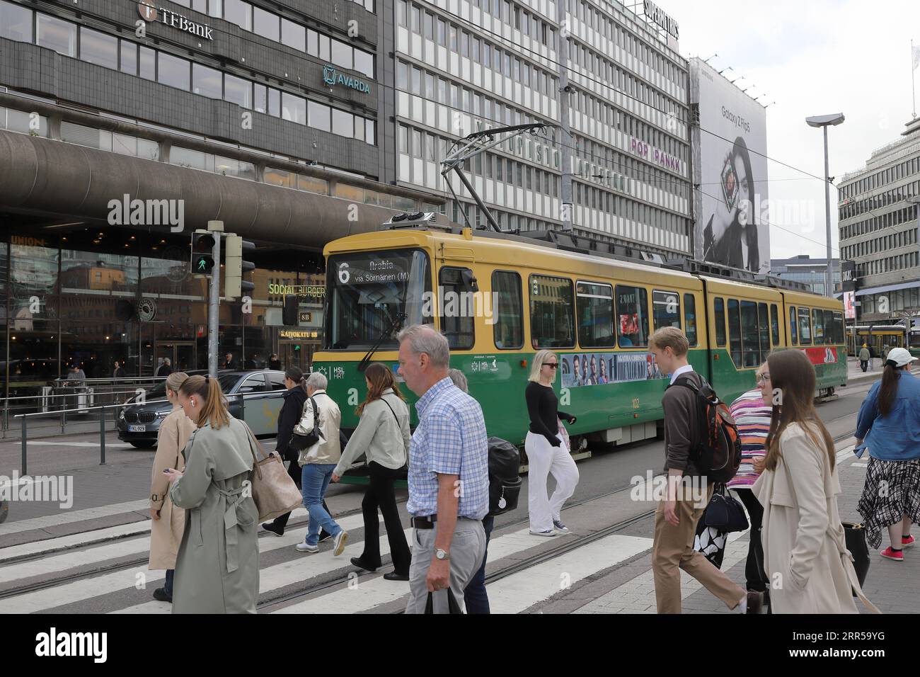 Helsinki, Finland - September 5, 2023: People crossing the crosswalk at the Kaivokatu street near the railway station and the Citycenter shopping mall Stock Photo