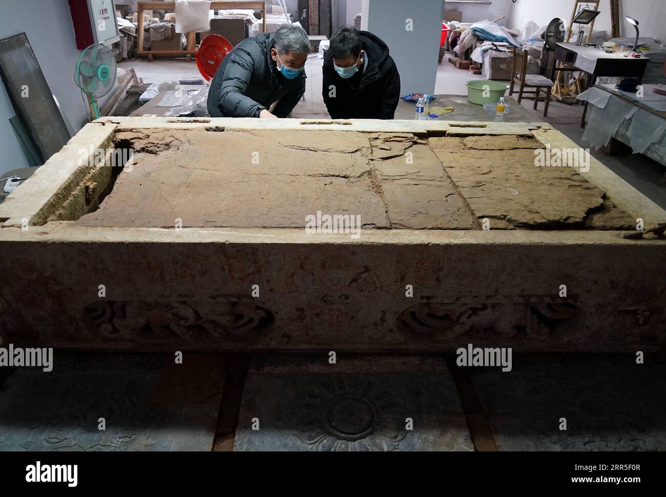 210104 -- ZHENGZHOU, Jan. 4, 2021 -- Staff members check a white marble bed uncovered from a tomb dating back to the Sui Dynasty 581-618 in Anyang, central China s Henan Province, Dec. 24, 2020. Archaeologists have discovered a 1,400-year-old tomb containing a white marble bed in central China s Henan Province, where elements of both Buddhism and a Persian religion have been found. The brick tomb dating back to the Sui Dynasty 581-618 was found in Long an District in the city of Anyang, said Jiao Peng, director of the excavation department under the city s research institute of cultural relics Stock Photo