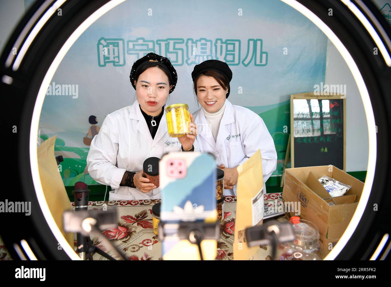 210105 -- YINCHUAN, Jan. 5, 2021 -- Hai Yan L and Ma Yan introduce products via livestreaming at Minning Hemei e-commerce poverty alleviation workshop in Yuanlong Village in Minning Township in Yinchuan, northwest China s Ningxia Hui Autonomous Region, Nov. 11, 2020. Xihaigu, one of China s most impoverished areas located in Ningxia, saw its last impoverished county removed from the national poverty list on Nov. 16, 2020. Over 60,000 farmers in Xihaigu have been relocated to Minning Township, which has converted from a town in Gobi desert to a modernized ecological relocation demonstration tow Stock Photo