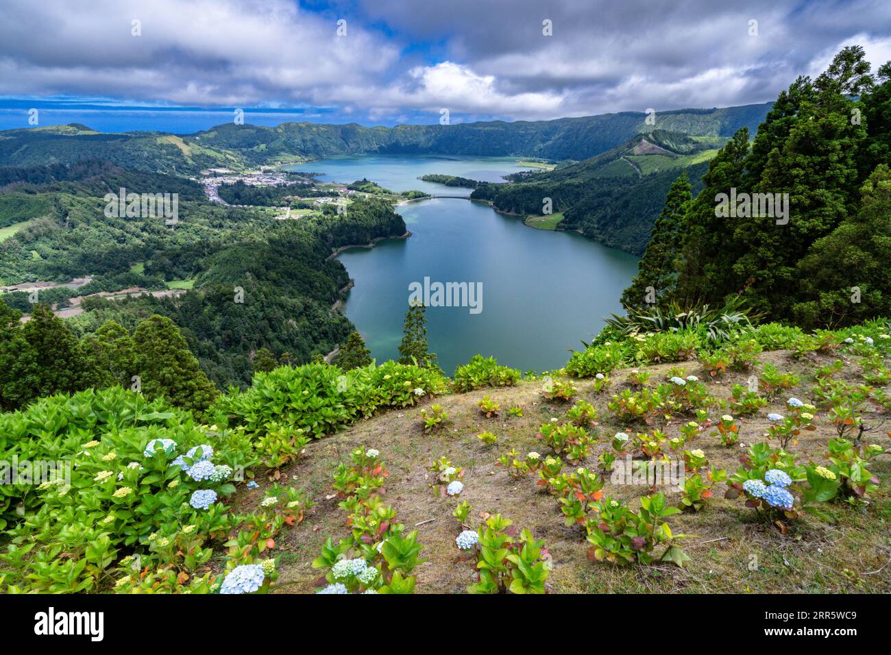 The twin lakes of Sete Cidades inside the massive crater of a dormant stratovolcanic in Sao Miguel, Azores, Portugal. The lakes known as Blue Lake and Green Lake show different colors due to the suns reflection. Stock Photo