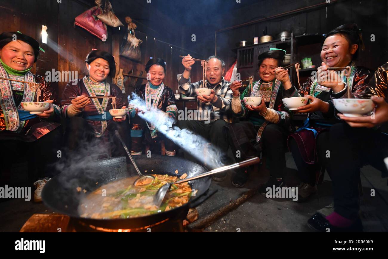 210120 -- RONGSHUI, Jan. 20, 2021 -- Lan Shengkui 3rd R tastes noodles made with red sorghum flour at Wuying Village, which lies on the border between south China s Guangxi Zhuang Autonomous Region and southwest China s Guizhou Province, Jan. 19, 2021. Wuying Village suffers from harsh environment and low agricultural yields, making it one of the most impoverished counties in Guangxi. In the summer of 2020, Lan Shengkui, a retired agricultural expert in variety improvement from Liuzhou Agricultural Science Institute, has come up with red sorghum, a crop that has strong tolerance to drought and Stock Photo