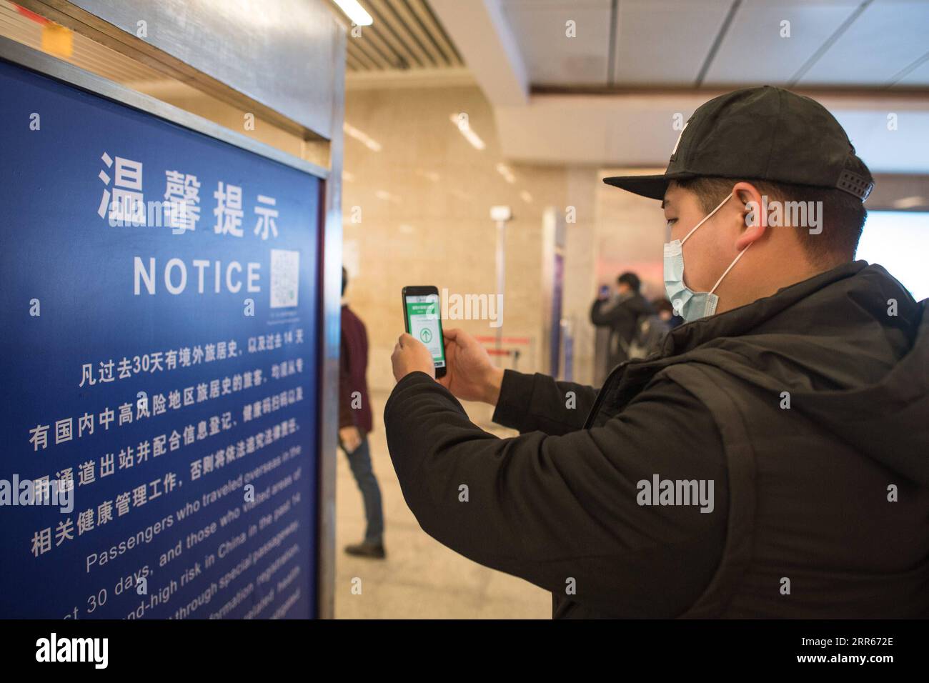 210128 -- SHANGHAI, Jan. 28, 2021 -- Gao Li scans the health QR code as he leaves Hankou Railway Station in Wuhan, central China s Hubei Province, Jan. 28, 2021. On the first day of the Spring Festival travel rush in 2021, Gao Li, a post-90s migrant worker in Shanghai, packed up his luggage and set foot on his way back to his hometown of Huangpi, Wuhan of central China for the Spring Festival. Before checking in, he fumbled for the negative nucleic acid testing report in his bag. Nothing could be more important than this piece of luggage . Two days ago, Shanghai medical workers came to Gao Li Stock Photo