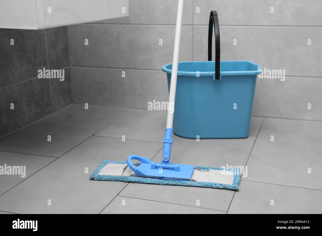 Mop and bucket on tiled floor in toilet Stock Photo Alamy