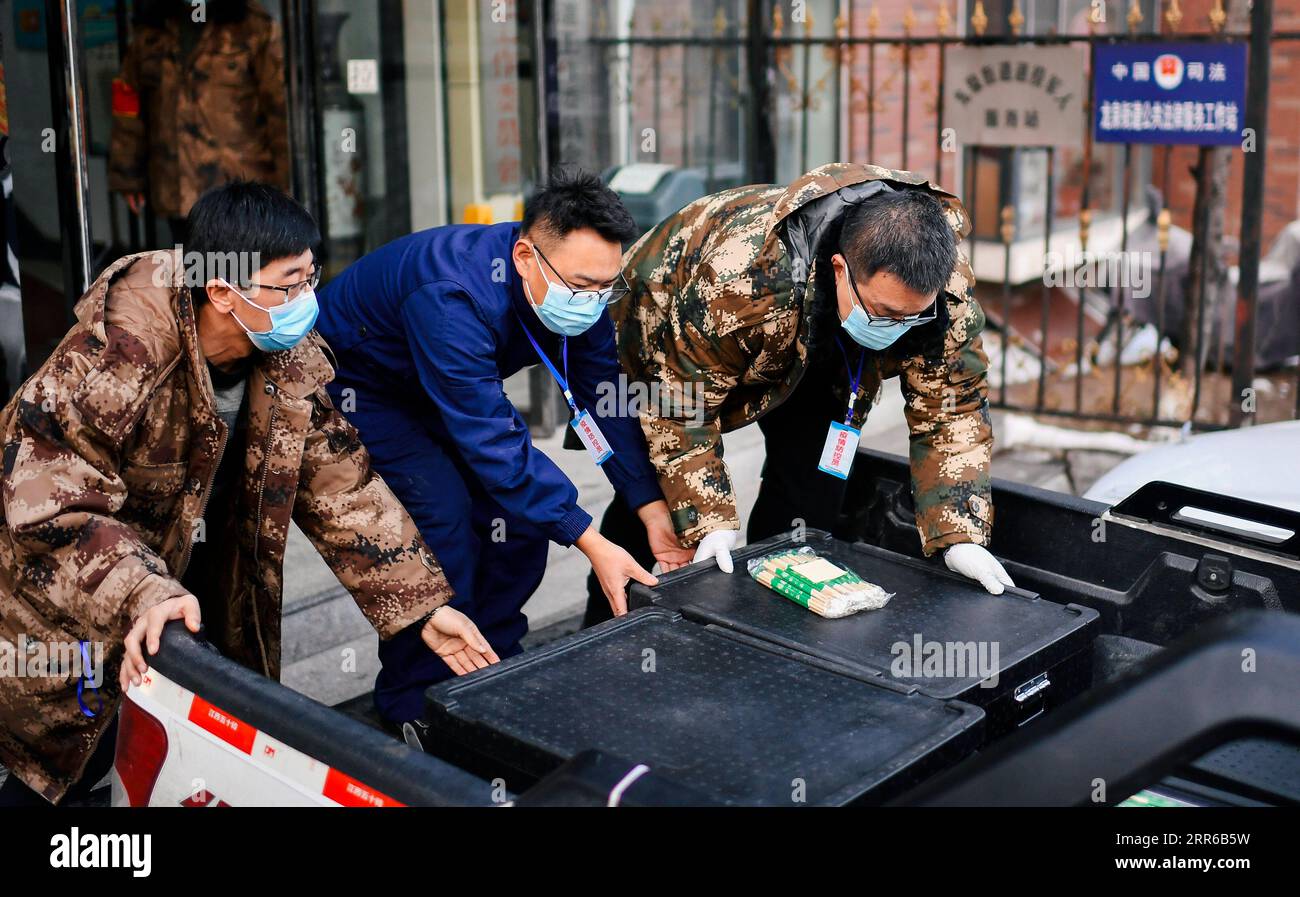 210203 -- TONGHUA, Feb. 3, 2021 -- Community staff load boxed meals before delivering them to communities at a sub-district office in Tonghua City of northeast China s Jilin Province, Jan. 23, 2021. The city is slowing down to curb the pandemic, but we re not closing up. Instead, we re busier than ever, said Zhao Hongxia, general manager of Jiahe Catering Company. The company was originally a boxed meal supplier for primary and secondary schools in Tonghua City. Since the COVID-19 outbreak in Tonghua, the company has accepted a new task of providing meals to front-line staff and people under q Stock Photo