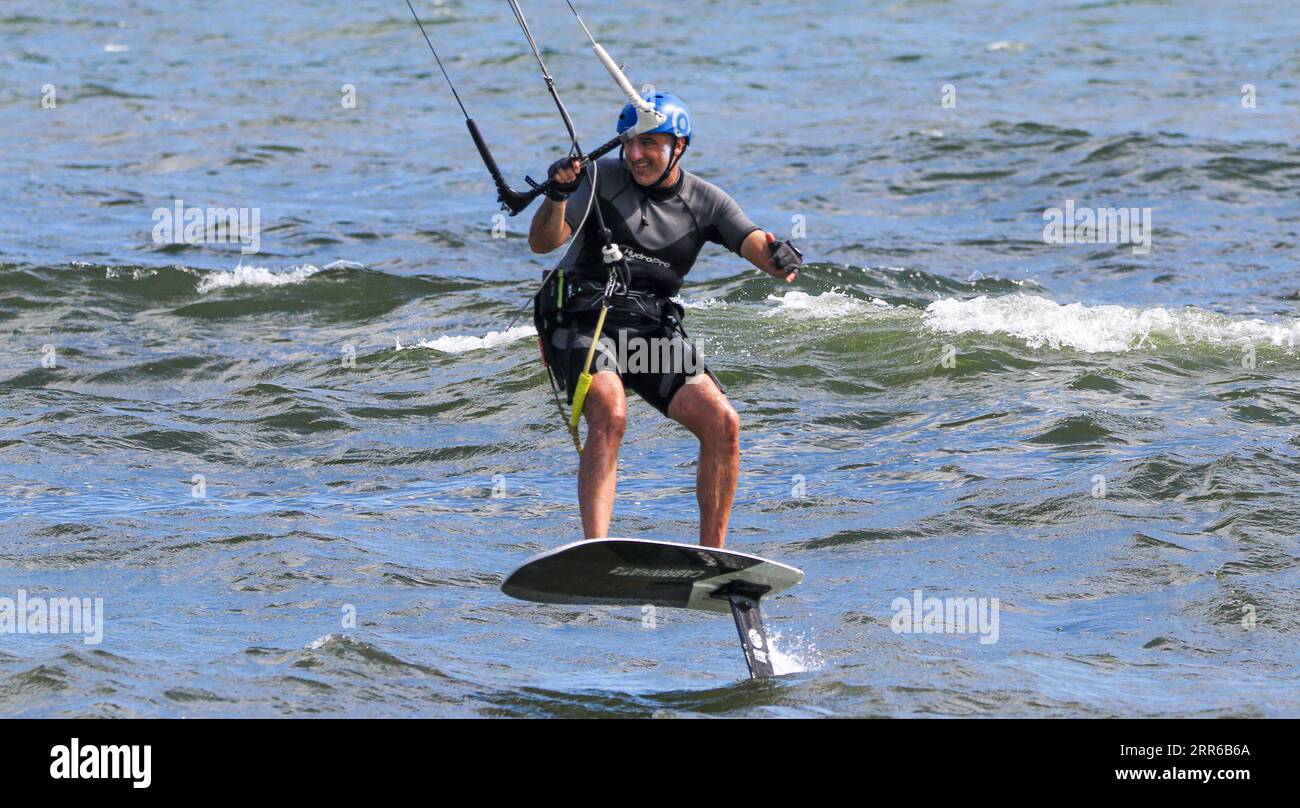 Gilgo Beach, New York, USA - 13 August 2023: One man kiteboarding, also know as kitesurfing in the ocean at Giglo Beach Long Islnad close up. Stock Photo