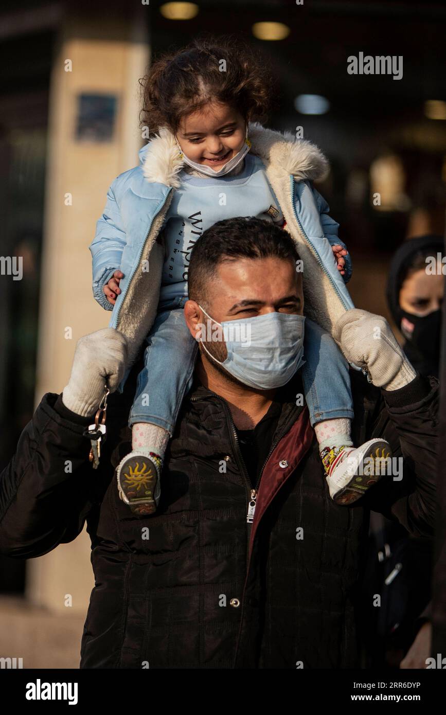 210209 -- TEHRAN, Feb. 9, 2021 -- A man with a face mask carries his child on a street in Tehran, Iran, on Feb. 8, 2021. Iran s Health Ministry reported 7,321 daily COVID-19 cases on Monday, raising the total nationwide infections to 1,473,756. The pandemic has so far claimed 58,536 lives in Iran, up by 67 in the past 24 hours, said Sima Sadat Lari, the spokeswoman for Iranian Ministry of Health and Medical Education, during her daily briefing. Photo by /Xinhua IRAN-TEHRAN-COVID-19 AhmadxHalabisaz PUBLICATIONxNOTxINxCHN Stock Photo