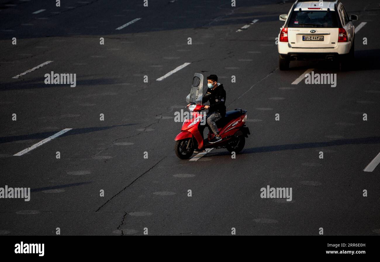 210209 -- TEHRAN, Feb. 9, 2021 -- A man with a face mask rides a motorbike on a street in Tehran, Iran, on Feb. 8, 2021. Iran s Health Ministry reported 7,321 daily COVID-19 cases on Monday, raising the total nationwide infections to 1,473,756. The pandemic has so far claimed 58,536 lives in Iran, up by 67 in the past 24 hours, said Sima Sadat Lari, the spokeswoman for Iranian Ministry of Health and Medical Education, during her daily briefing. Photo by /Xinhua IRAN-TEHRAN-COVID-19 AhmadxHalabisaz PUBLICATIONxNOTxINxCHN Stock Photo