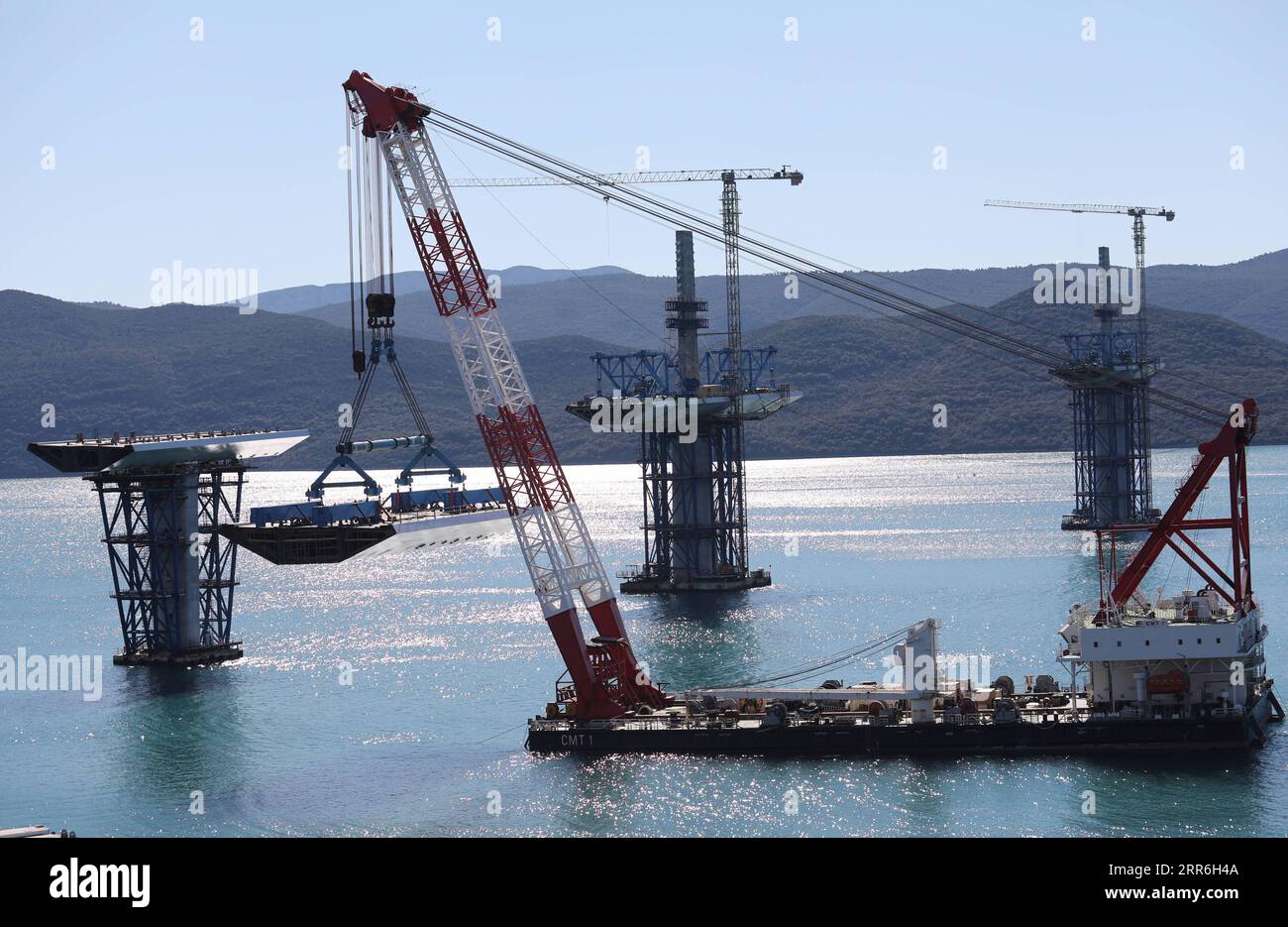 210215 -- KOMARNA CROATIA, Feb. 15, 2021 -- A crane carries a steel box girder to connect the Croatian mainland with the first sea-based pillar of the Peljesac Bridge near Komarna, Croatia, Feb. 15, 2021. The construction of the Peljesac Bridge, the biggest infrastructure project in Croatia, will be completed in June 2022, Prime Minister Andrej Plenkovic announced on Monday after visiting the site. The 2.4-kilometer-long Peljesac Bridge connects Croatia s southernmost Dubrovnik-Neretva County to the rest of the mainland, giving the southeastern European country a continuous land link that bypa Stock Photo