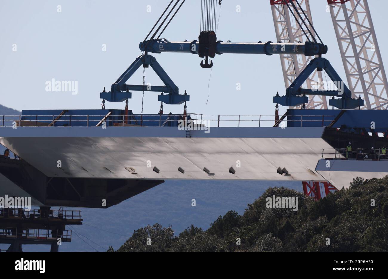 210215 -- KOMARNA CROATIA, Feb. 15, 2021 -- A crane carries a steel box girder to connect the Croatian mainland with the first sea-based pillar of the Peljesac Bridge near Komarna, Croatia, Feb. 15, 2021. The construction of the Peljesac Bridge, the biggest infrastructure project in Croatia, will be completed in June 2022, Prime Minister Andrej Plenkovic announced on Monday after visiting the site. The 2.4-kilometer-long Peljesac Bridge connects Croatia s southernmost Dubrovnik-Neretva County to the rest of the mainland, giving the southeastern European country a continuous land link that bypa Stock Photo