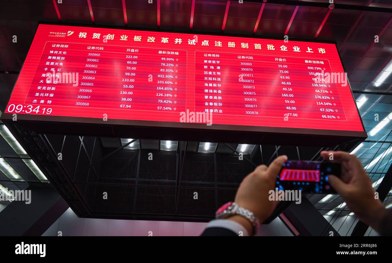 210218 -- BEIJING, Feb. 18, 2021 -- A man takes photos of a big screen displaying stock prices at the listing ceremony of the first batch of registration-based initial public offerings IPOs of enterprises debuted on the ChiNext board at Shenzhen Stock Exchange in Shenzhen, south China s Guangdong Province, Aug. 24, 2020.  Xinhua Headlines: China s capital market embraces Year of the Ox with reforms, greater appeal MaoxSiqian PUBLICATIONxNOTxINxCHN Stock Photo