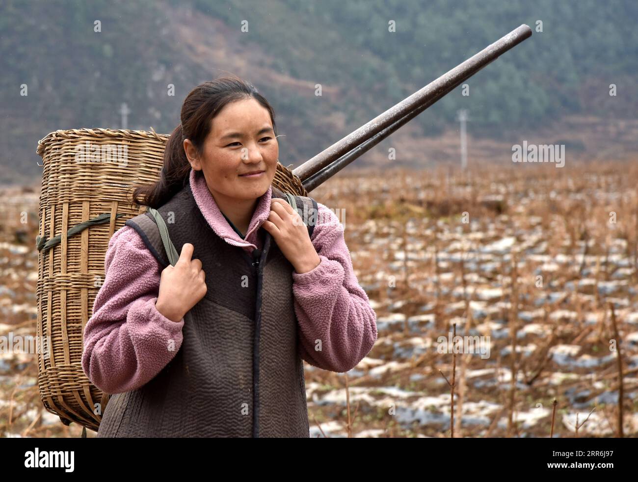 210218 -- CHENGDU, Feb. 18, 2021 -- Bamu Yubumu is on the way to the fields in Yuexi County of Liangshan Yi Autonomous Prefecture in southwest China s Sichuan Province, Feb. 17, 2021. Bamu Yubumu was known as a migrant mother in an iconic photo during a Spring Festival travel rush 11 years ago. Recently, she and her husband Wuqi Shiqie have embarked on their new career of sea cucumber cultivation in the coastal Fujian Province. During this year s Spring Festival holiday, Bamu and her husband returned to their hometown in southwest China s Sichuan for a visit. Amid slack season of agricultural Stock Photo