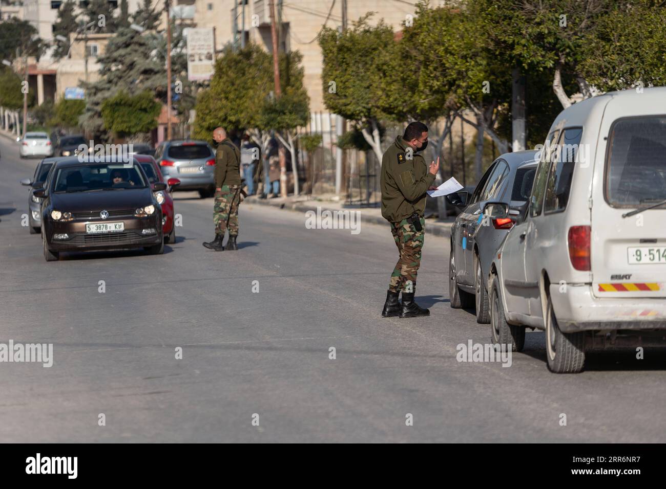 210224 -- BETHLEHEM, Feb. 24, 2021 -- Palestinian police officers work at a checkpoint at one of the main roads of Beit Sahour near the West Bank city Bethlehem, Feb. 24, 2021. The Governor of Bethlehem announced the closure of Beit Sahour for 48-hours starting from 12:00 am Wednesday, after increase of the numbers of COVID-19 infections. Photo by /Xinhua MIDEAST-BETHLEHEM-COVID-19-CHECKPOINT LuayxSababa PUBLICATIONxNOTxINxCHN Stock Photo