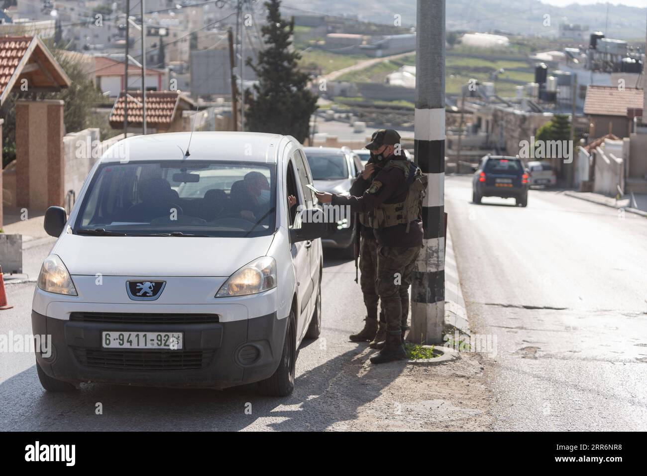 210224 -- BETHLEHEM, Feb. 24, 2021 -- Palestinian police officers work at a checkpoint at one of the main roads of Beit Sahour near the West Bank city Bethlehem, Feb. 24, 2021. The Governor of Bethlehem announced the closure of Beit Sahour for 48-hours starting from 12:00 am Wednesday, after increase of the numbers of COVID-19 infections. Photo by /Xinhua MIDEAST-BETHLEHEM-COVID-19-CHECKPOINT LuayxSababa PUBLICATIONxNOTxINxCHN Stock Photo