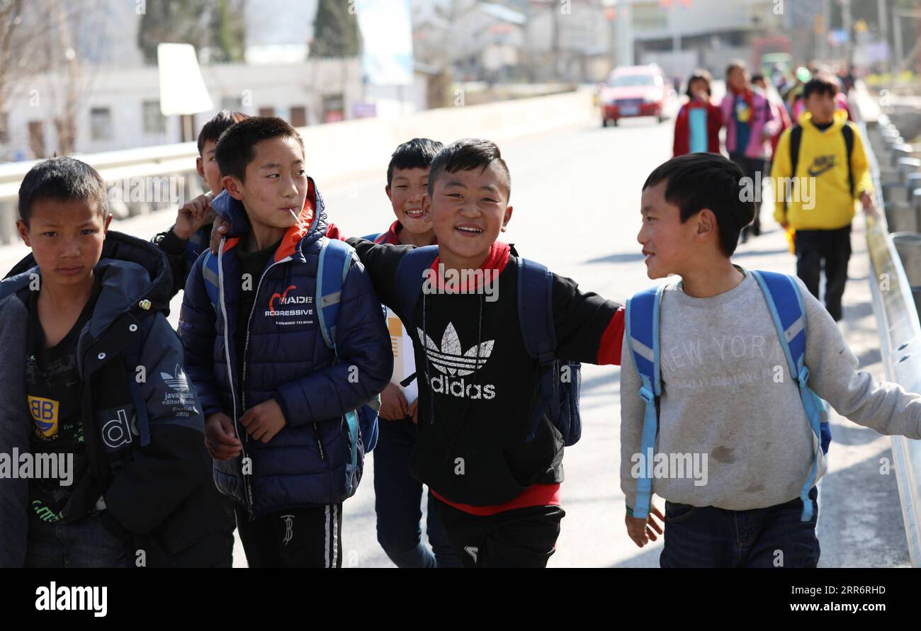 210226 -- LIANGSHAN, Feb. 26, 2021 -- Jijue Jizhu 2nd R and his friends walk on their way home after school in southwest China s Sichuan Province, Feb. 24, 2021. On a snowy day in February 2018, a nine-year-old boy carrying his younger brother on the back went downhill in Liangshan Yi Autonomous Prefecture, Sichuan Province, on the way to his maternal grandfather s house at a relocation site. Xinhua correspondent captured the moment. The photo moved many Chinese people. With the help of targeted poverty alleviation, Jijue Jizhu s family bid farewell to the adobe house in a mountainous area and Stock Photo