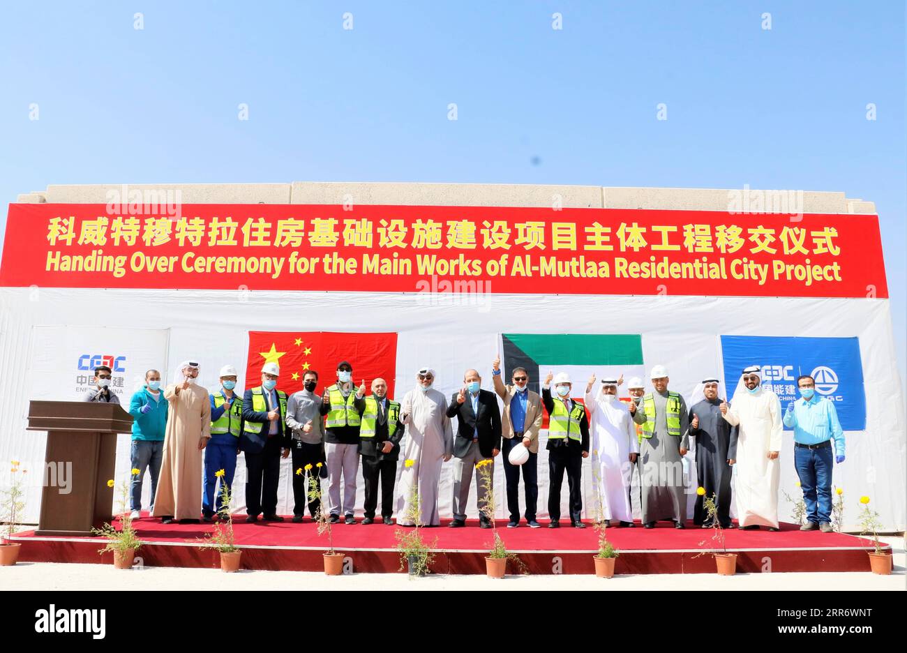 210302 -- JAHRA GOVERNORATE, March 2, 2021 -- Representatives of China Gezhouba Group Corporation CGGC and the Kuwaiti side pose for a photo at the handover ceremony at the construction site of a CGGC project in a desert of Jahra Governorate, Kuwait, March 2, 2021. China Gezhouba Group Corporation CGGC, affiliated to China Energy Engineering Group Co., Ltd., handed over on Tuesday the second batch of its housing infrastructure project to the Kuwaiti side, marking the handover of the main works of the project. Photo by Liu Lianghaoyue/Xinhua KUWAIT-JAHRA GOVERNORATE-CHINESE COMPANY-PROJECT-HAND Stock Photo