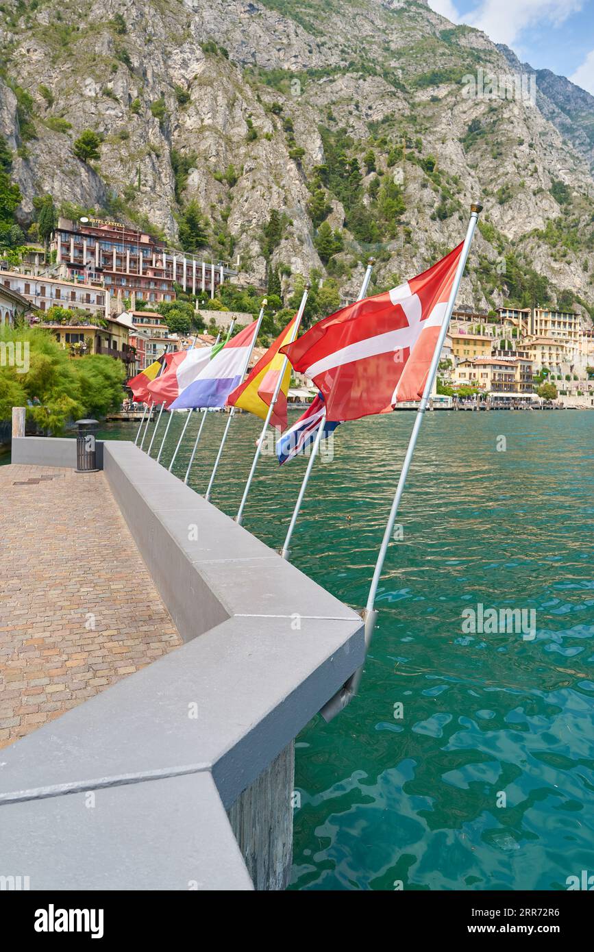 Flags of many countries on the promenade of the resort Limone Sul Garda on Lake Garda in Italy Stock Photo