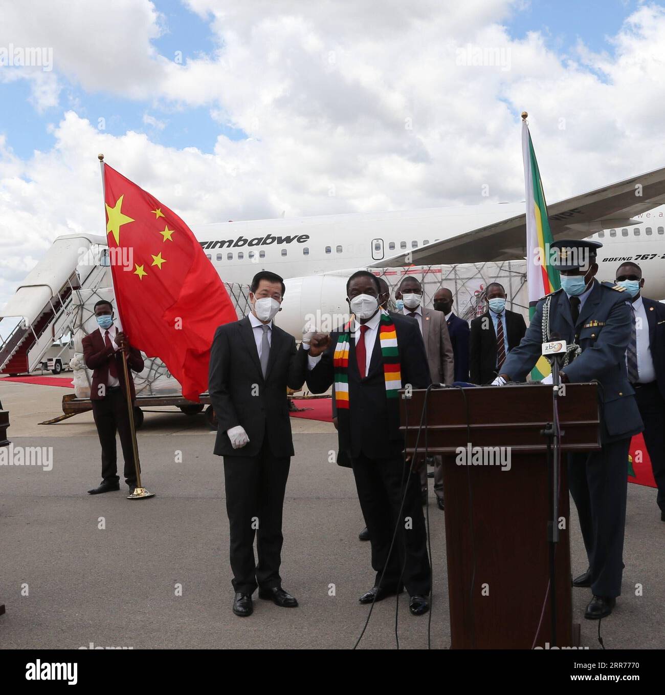 210316 -- HARARE, March 16, 2021 -- Zimbabwean President Emmerson Mnangagwa 2nd L, front and Chinese Ambassador to Zimbabwe Guo Shaochun 1st L, front pose for a photo as a batch of COVID-19 vaccines arrive at Robert Gabriel Mugabe International Airport in Harare, Zimbabwe, on March 16, 2021. Zimbabwe on Tuesday received a second batch of Sinopharm doses donated by China plus an additional Sinovac doses commercially procured by the government.  ZIMBABWE-HARARE-CHINA-COVID-19 VACCINE-ARRIVAL ZhangxYuliang PUBLICATIONxNOTxINxCHN Stock Photo