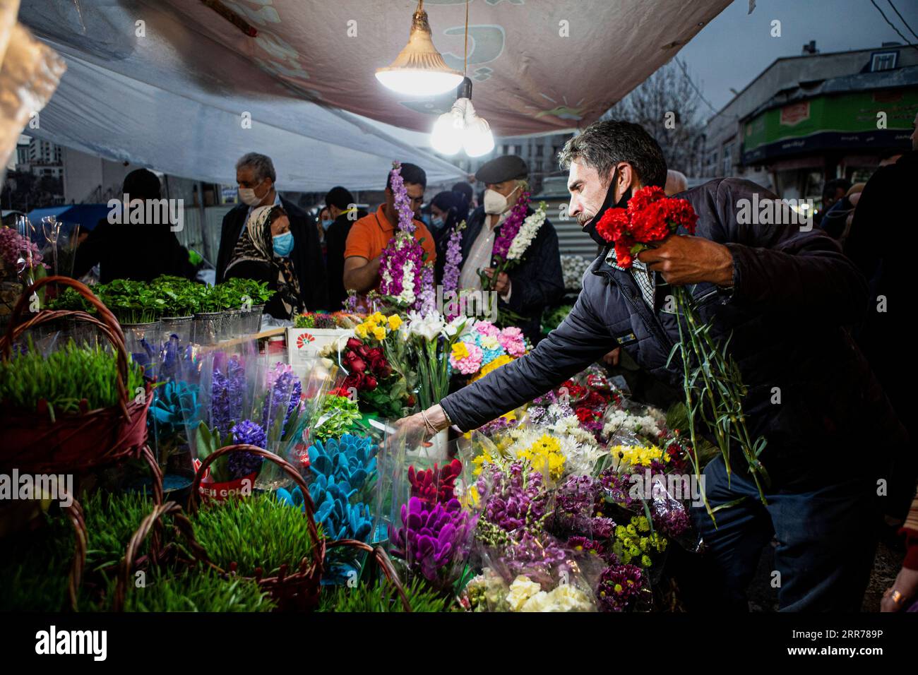 210319 TEHRAN, March 19, 2021 A man buys flowers at a bazaar