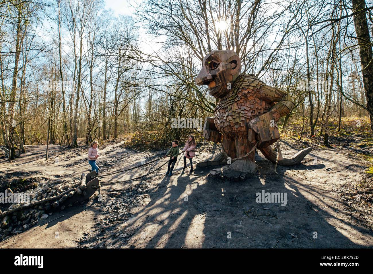210321 -- BOOM, March 21, 2021 -- Children play with a troll at the De Schorre forest park in Boom, Belgium, March 20, 2021. Danish artist Thomas Dambo and his team built seven giant trolls from reclaimed wood at the De Schorre forest park in northern Belgium in 2019. These giant wooden sculptures are dotted around the forest. The United Nations General Assembly proclaimed March 21 as the International Day of Forests which celebrates and creates awareness on the importance of all types of forests and on the need to preserve and care for the world s woodlands. This year the theme for the Intern Stock Photo