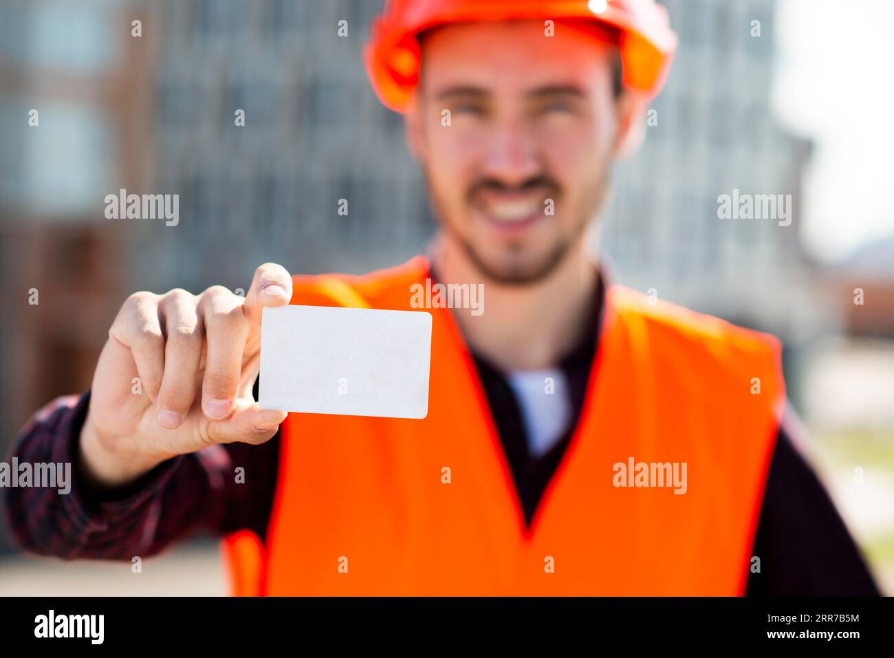 Medium shot portrait construction engineer holding business card Stock Photo