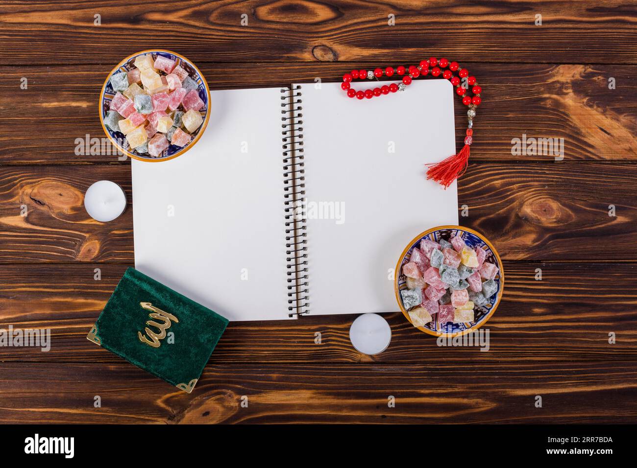 Overhead view spiral notebook with delight lukum bowls kuran red prayer beads wooden desk Stock Photo