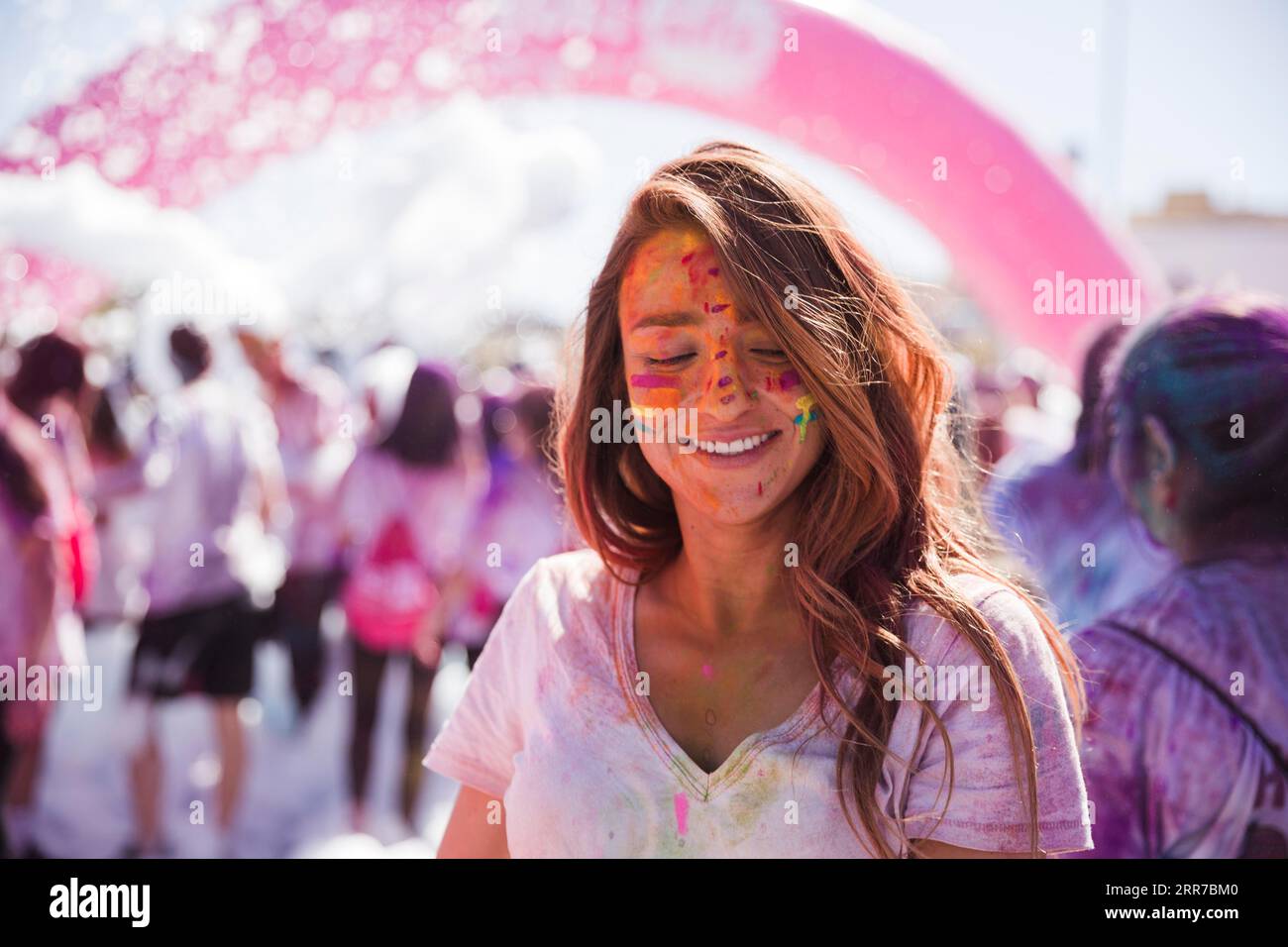 Portrait smiling young woman with holi color face Stock Photo
