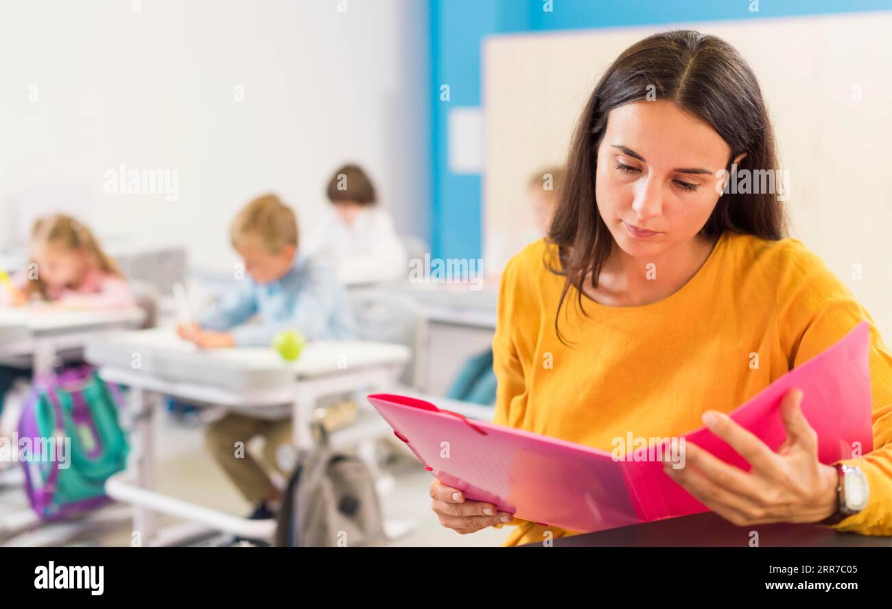 Teacher looking through her notes Stock Photo - Alamy