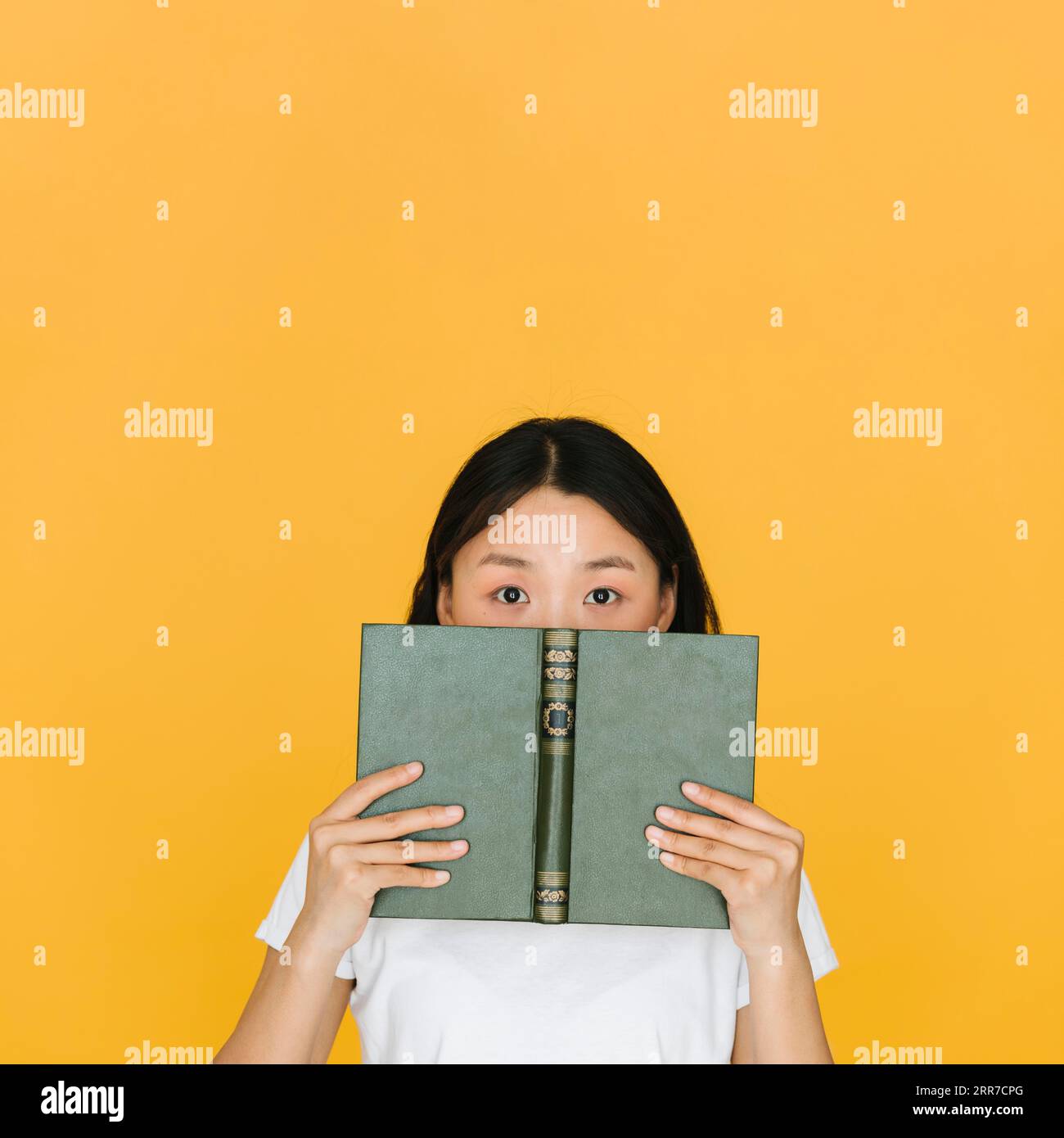 Young woman with book looking camera Stock Photo