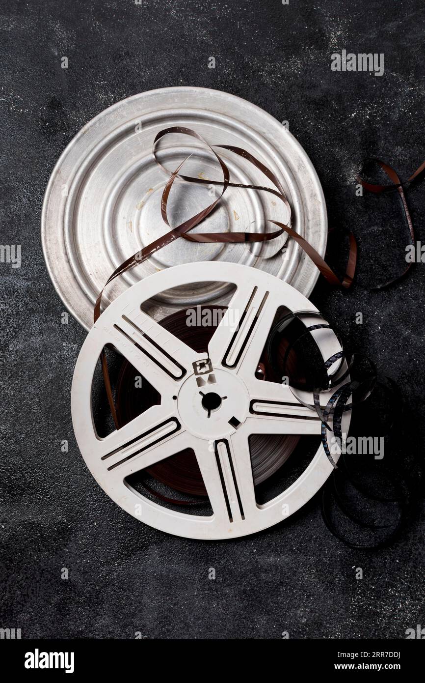 Film reel canister with negative stripes dark background Stock Photo