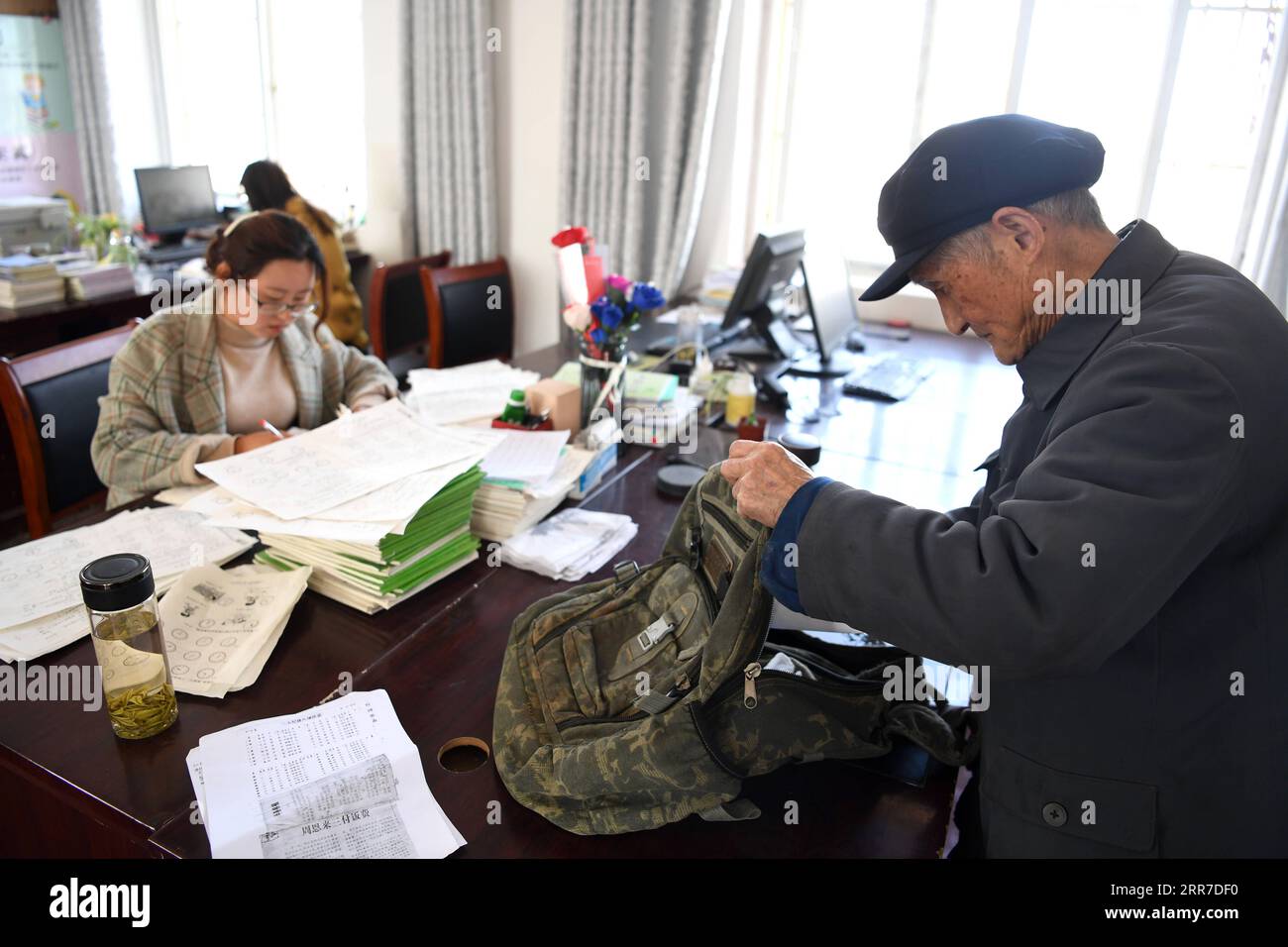 210326 -- HEFEI, March 26, 2021 -- Yan Mingyou prepares to head to Fuxing Primary School at the office of Zhuwan Primary School in Zhuwan Township of Dingyuan County, Chuzhou City, east China s Anhui Province, March 23, 2021. Yan Mingyou, 92, is still at the post of teaching music at rural elementary schools. Retiring as a rural teacher in 1990, Yan has been volunteering to teach music to students in rural schools. Back to 1953, Yan left the army and returned to his hometown Zhuwan Township in Dingyuan County. He gave up a better job at local government and chose to work in rural schools, teac Stock Photo