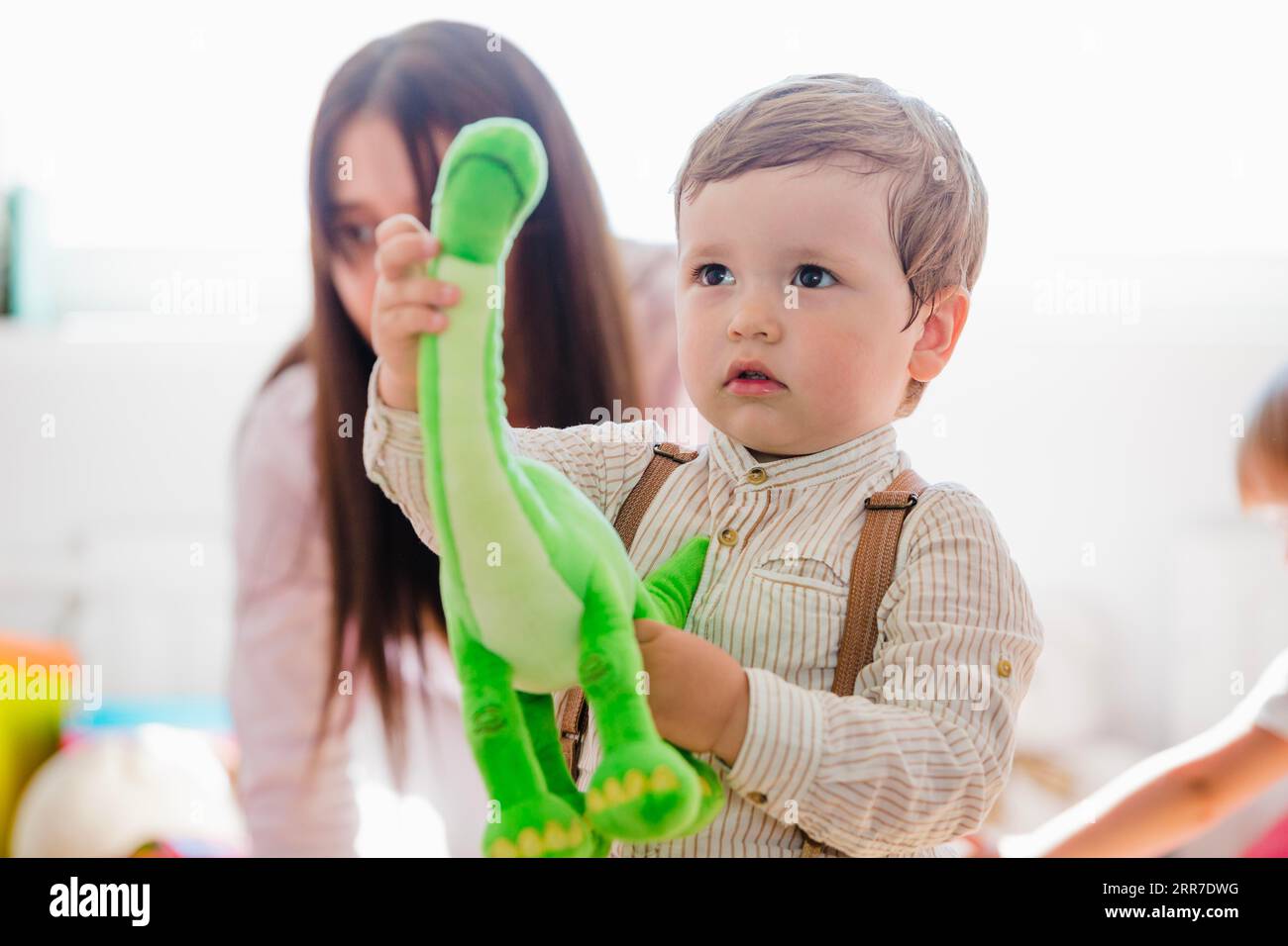 Little boy holding green dinosaur toy Stock Photo - Alamy