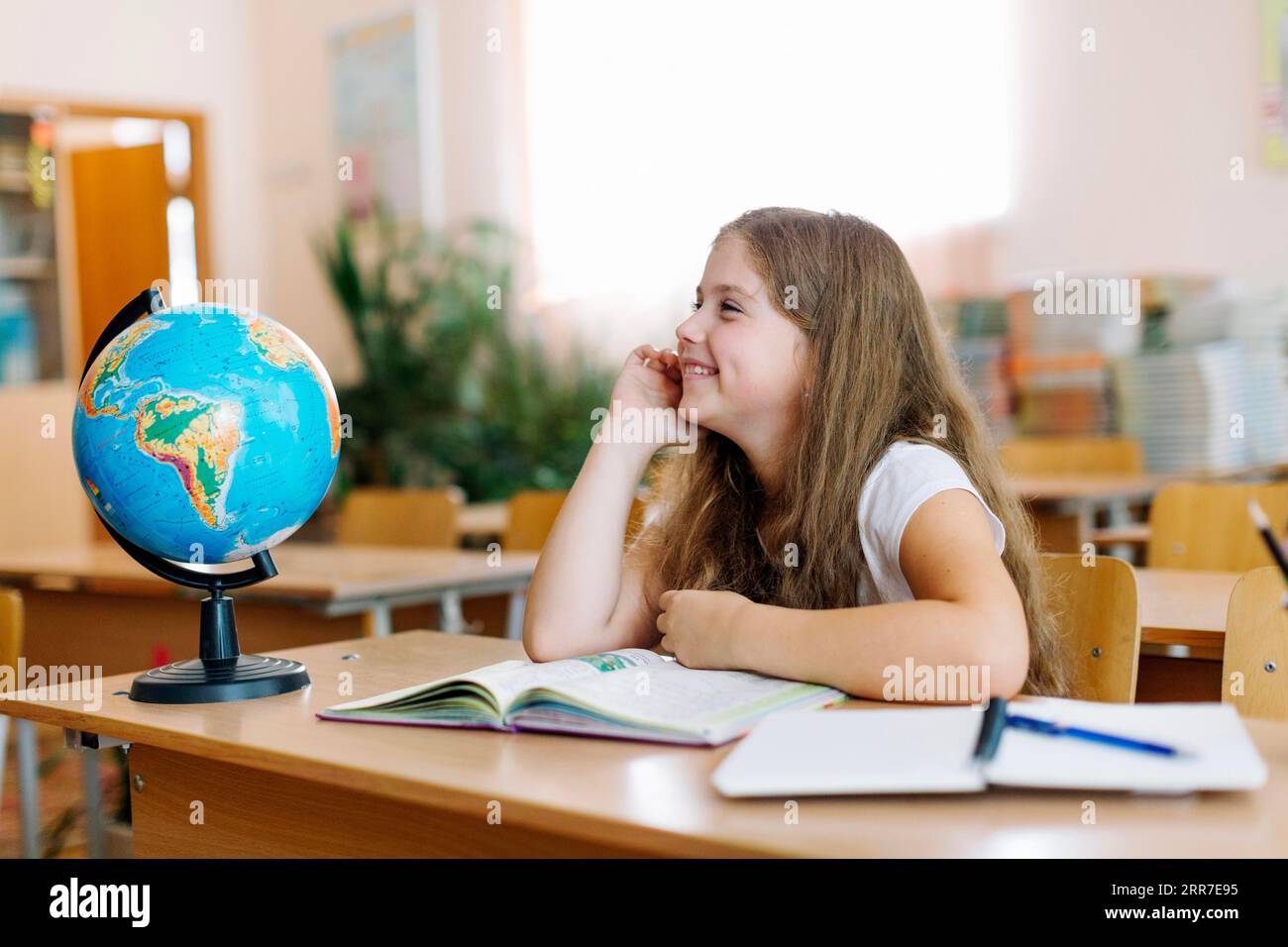 Schoolgirl smiling desk Stock Photo - Alamy