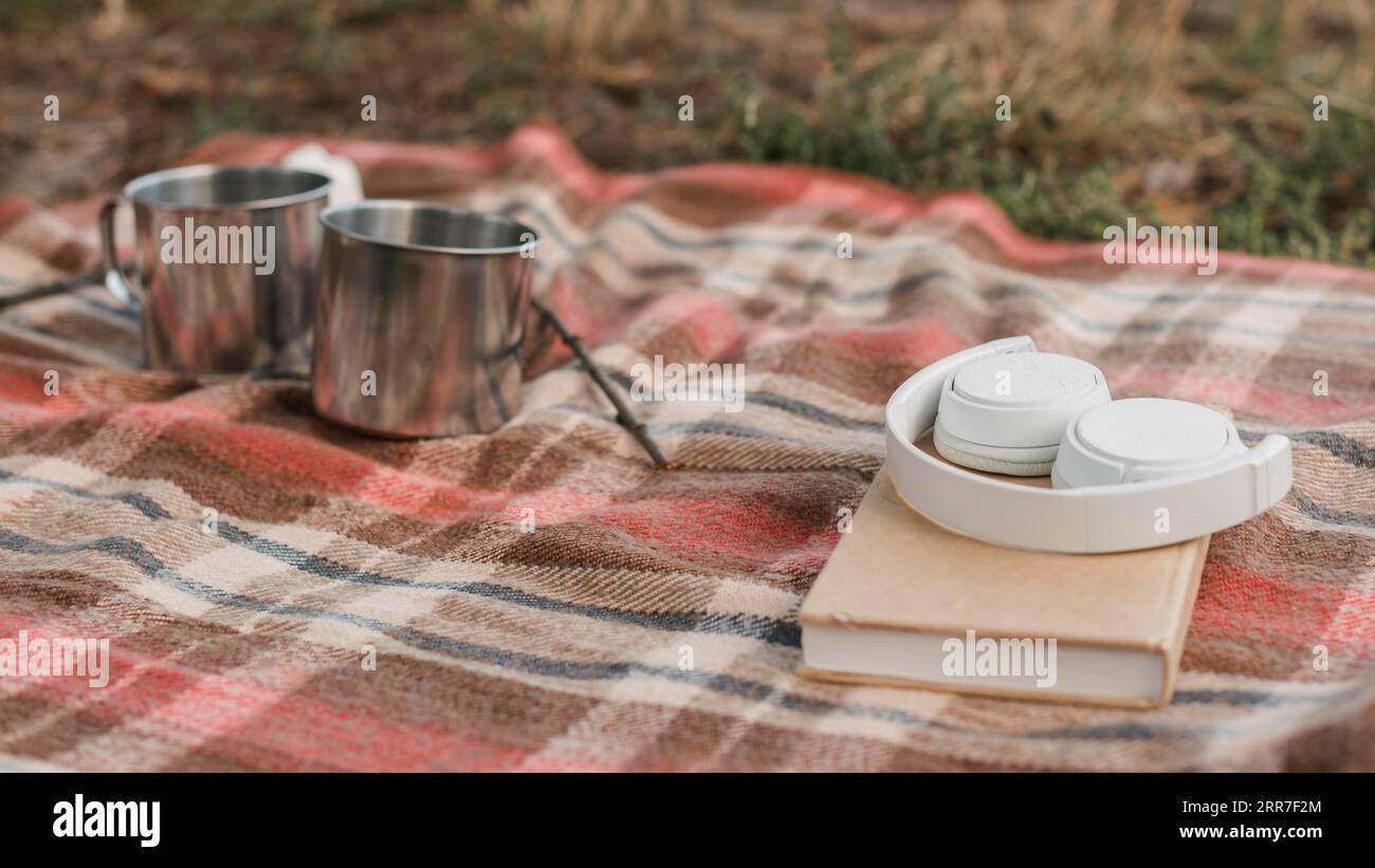 Camping outdoors with book mugs hot drinks Stock Photo