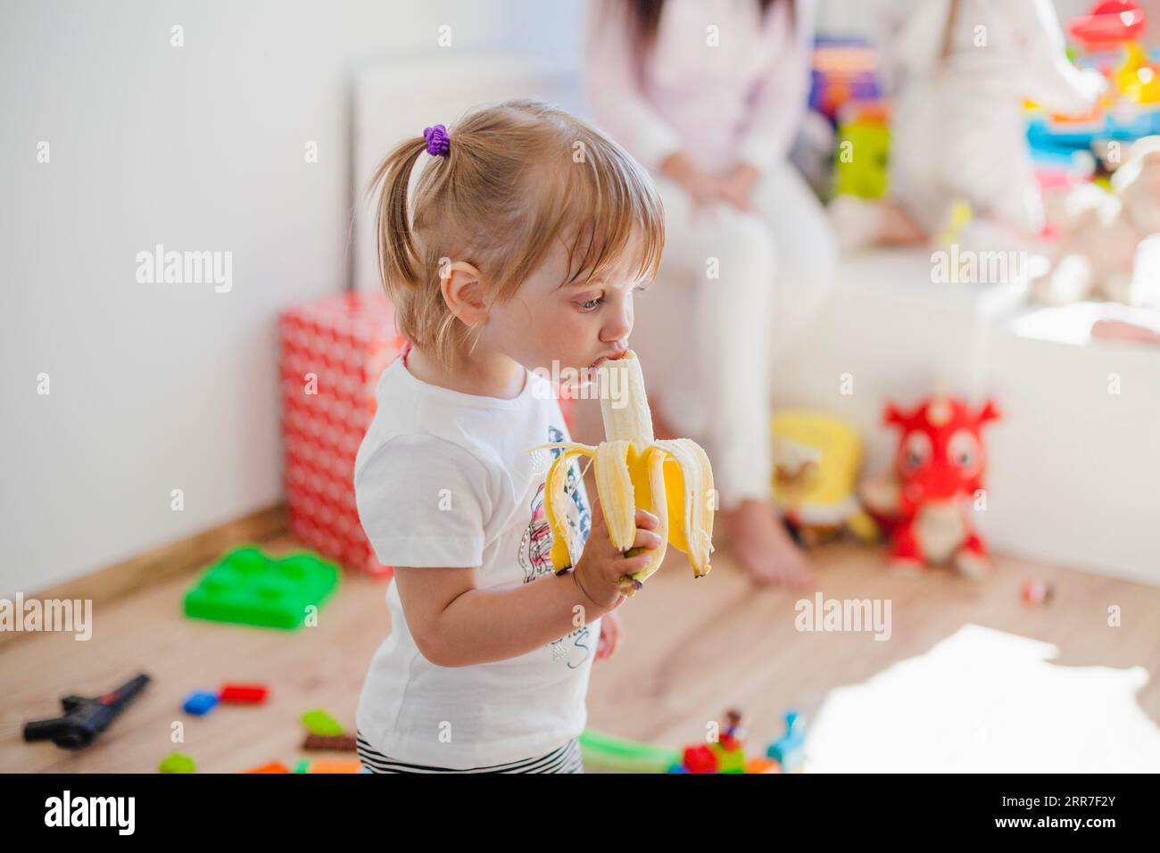 Charming girl enjoying banana Stock Photo