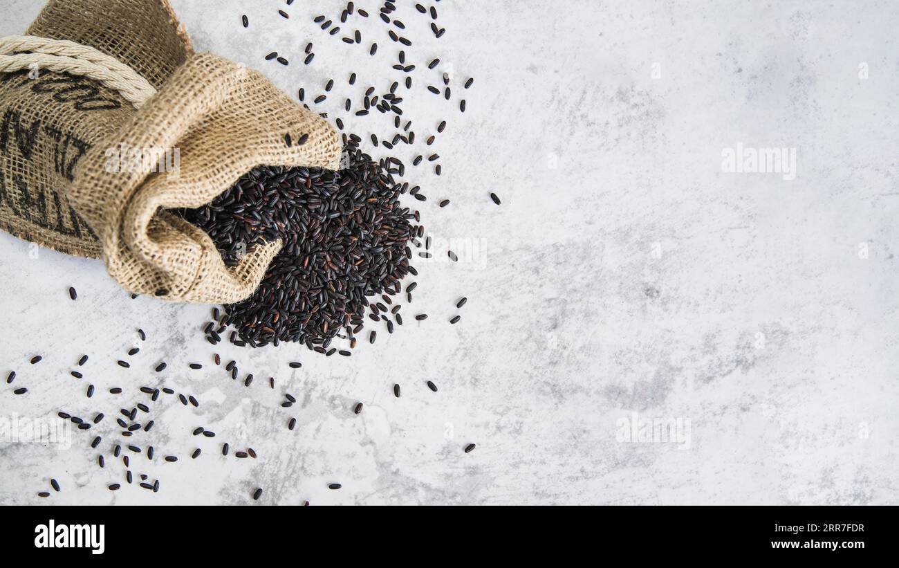 Composition scattered black rice sack Stock Photo