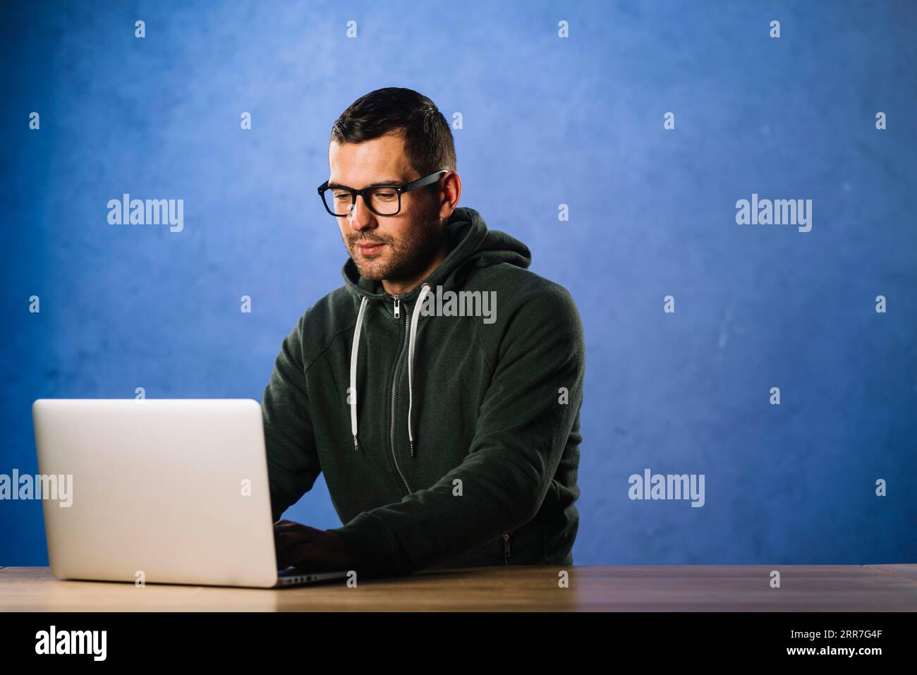 Hacker with glasses looking laptop Stock Photo
