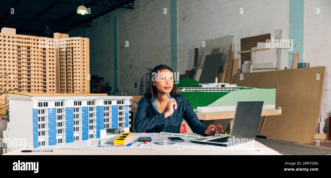 Pensive african american lady with laptop model building Stock Photo