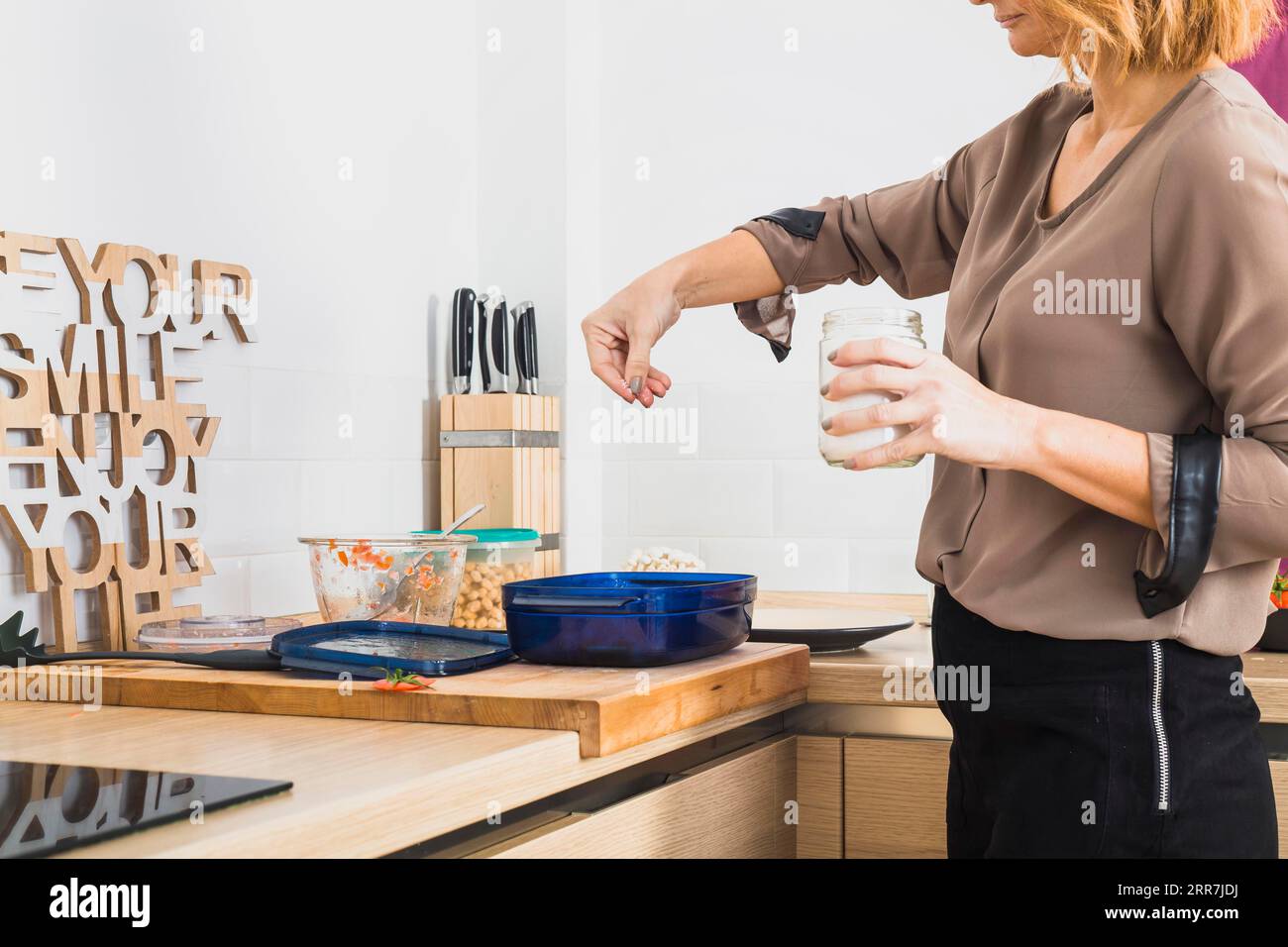 Slating Food Female standing kitchen salting food Stock Photo - Alamy