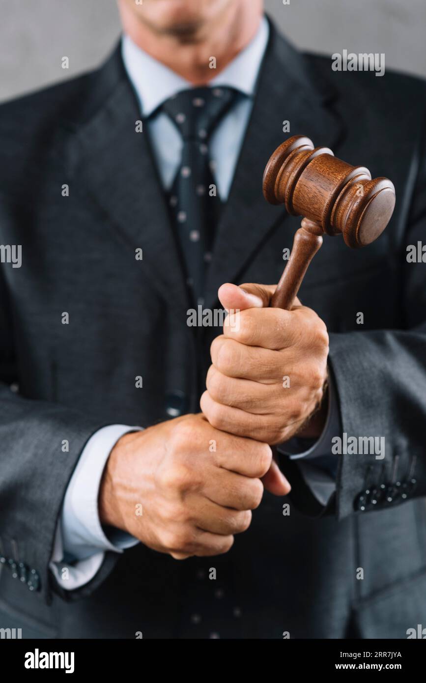 Mid section male lawyer holding wooden mallet hand Stock Photo Alamy