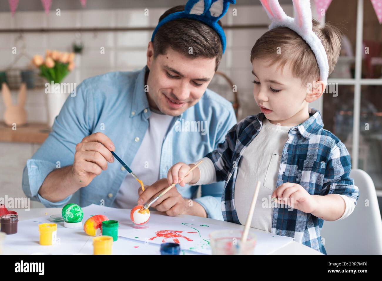 Father son painting eggs easter together Stock Photo