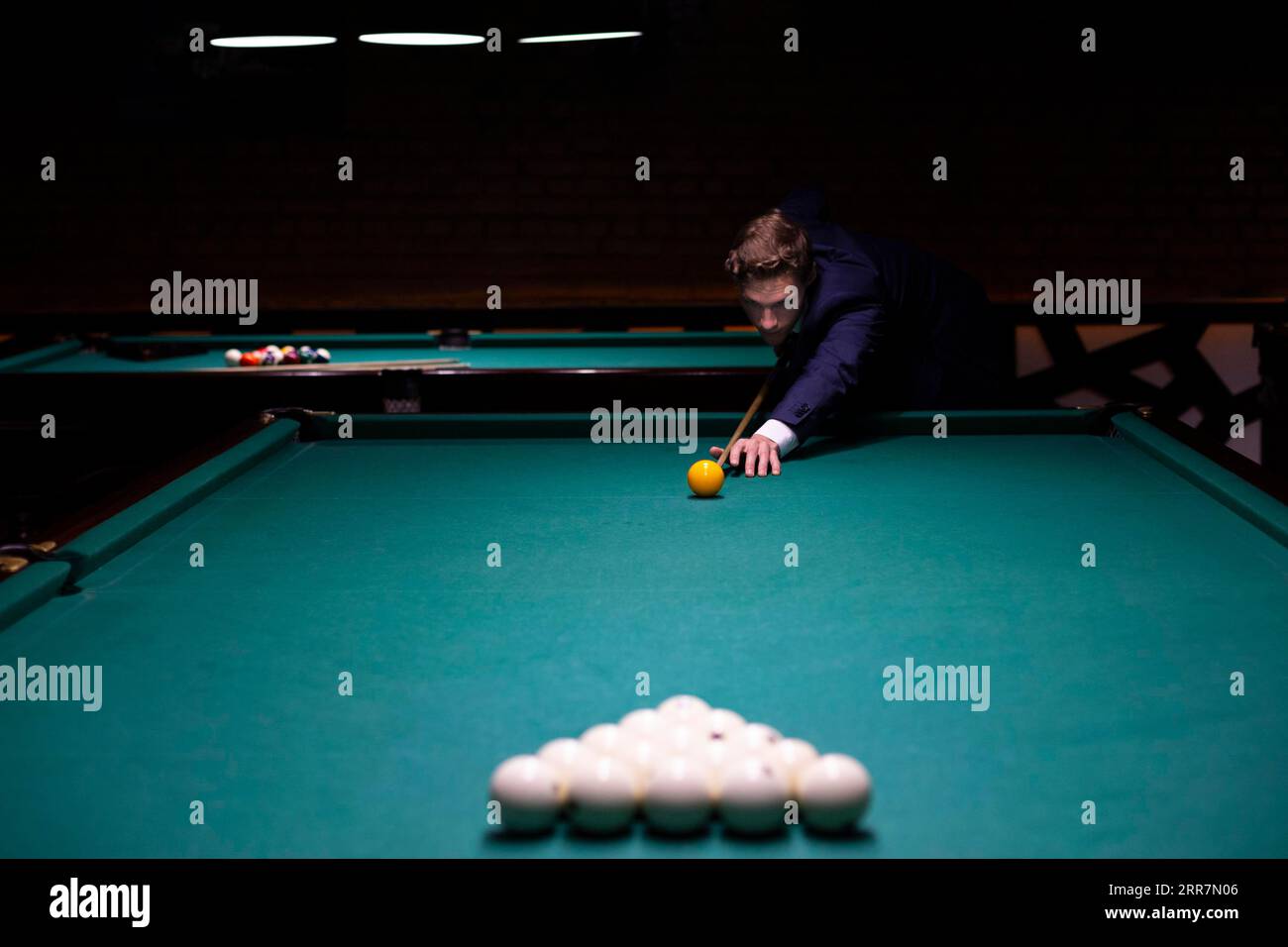 Medium shot man suit playing billiard Stock Photo